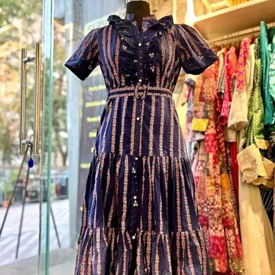 Step back in time with this vintage-inspired dress. It features a beautiful floral and striped pattern, a tiered skirt, and a stunning three-layer ruffle neckline, creating a look that is both romantic and playful.