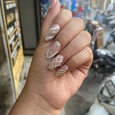 A stunning pre-bridal set for a special client. This design features a nude base with white patterns, intricate rhinestone work, and a textured, sugar-effect nail.