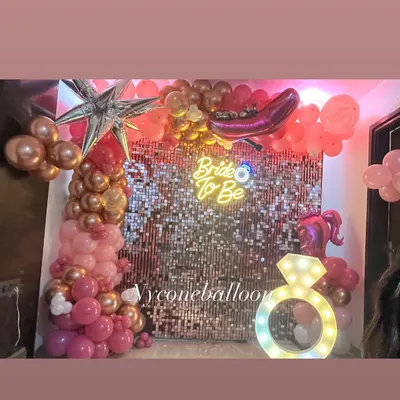 The complete setup for a fun 'Bride to Be' party. The pink sequin wall, neon sign, and balloon arch create a fantastic photo booth for the bride and her friends.