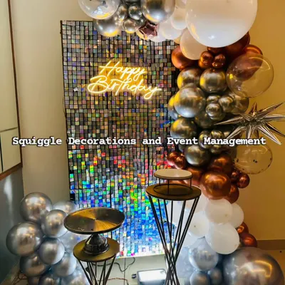 A stunning holographic shimmer wall paired with a 'Happy Birthday' neon sign. The chrome, copper, and white balloon garland adds a touch of modern elegance to this birthday setup.