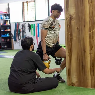 Rehabilitation is not rest; it's smart adaptation. Here, I am guiding a client through a targeted exercise to build strength and stability around an injured area, ensuring they keep moving forward safely.