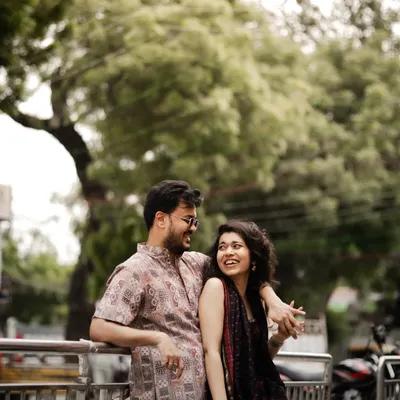A candid, happy moment on a city street, capturing the effortless chemistry and laughter between the couple.