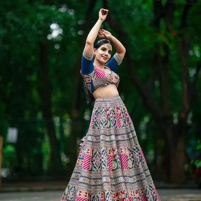 A full-length shot capturing the dynamic movement of a traditional patterned lehenga. This kind of image is essential for lookbooks to show how the garment flows.