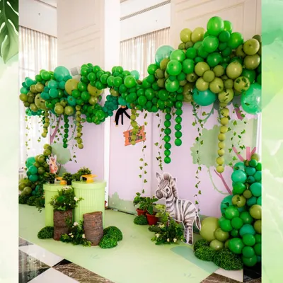 Welcome to the jungle. We created a lush, immersive world for a wild-themed birthday, using layers of green balloons to form a jungle canopy and cute animal props to bring the safari to life.