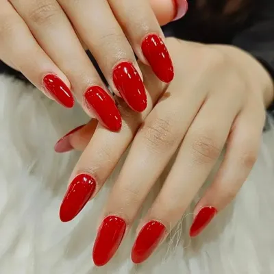 A classic, glossy, and perfectly shaped set of bright red almond nails. A timeless look that is always in style.