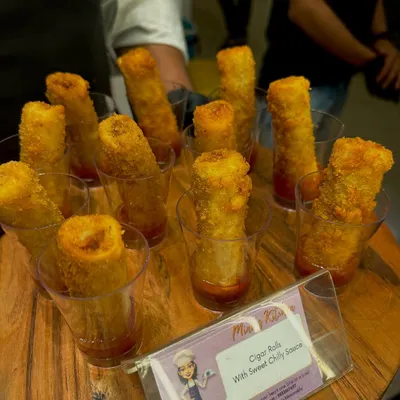 Crispy cigar rolls served in individual glasses with a sweet chili sauce. This presentation is elegant, easy for guests to handle, and perfect for house parties.