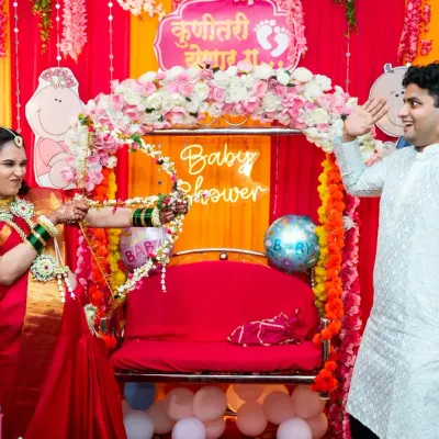 A playful moment during a traditional baby shower, or Godh Bharai. The mother-to-be playfully aims a floral bow and arrow at her husband, a fun ritual that I love to capture.
