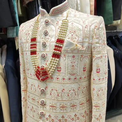 This is what I call extravagance for the groom's special day. A fully embroidered off-white sherwani paired with a striking red and pearl mala creates a look of pure royalty.