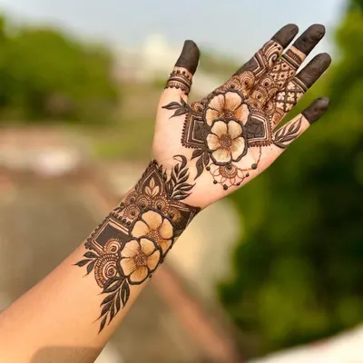 A beautiful and modern floral design on the back of the hand. The use of shading and negative space gives the flowers a realistic, 3D effect.