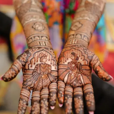 The heart of the wedding story, captured in henna. This design features intricate portraits of the bride and groom on each palm, ready to come together in a beautiful union.