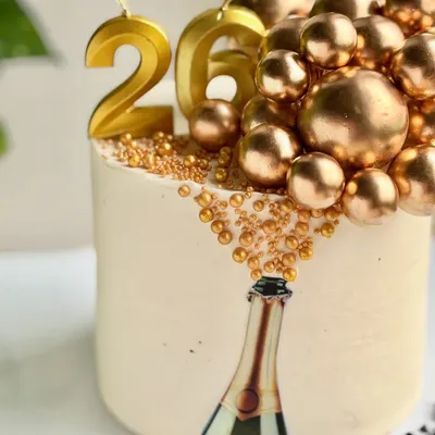 Who needs champagne when the cake’s already popping? This 26th birthday cake features an edible image of a champagne bottle with golden bubbles made of sprinkles and spheres cascading out.