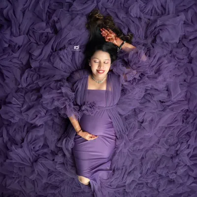 A unique overhead shot, with the mom-to-be looking serene in a sea of purple tulle. This artistic portrait is one of my favorite ways to showcase the beauty of pregnancy.