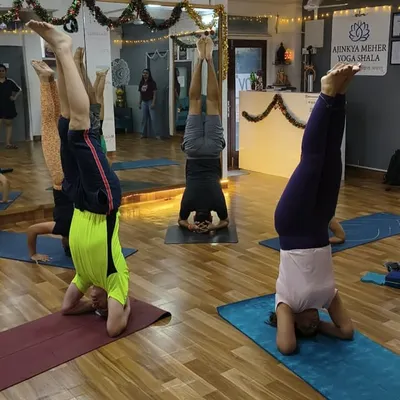 A group of students holding Sirsasana (Headstand), demonstrating the collective energy and focus in our inversion classes.