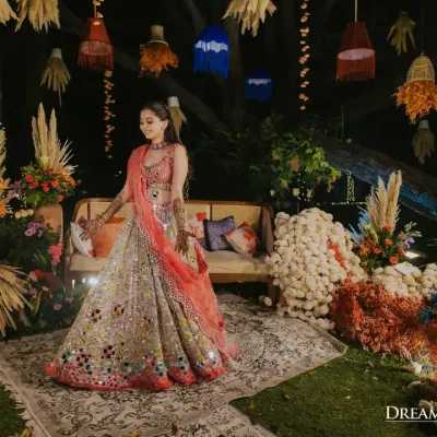 The bride, radiant in her colorful lehenga, at her Marrakesh-themed Mehendi. The decor, with its hanging lanterns and vibrant florals, created the perfect backdrop for her grand entrance.