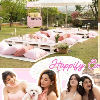 A dreamy puppy picnic setup for a brand event, featuring low pallet tables, plush pink cushions, and elegant white umbrellas for a chic and comfortable outdoor experience.