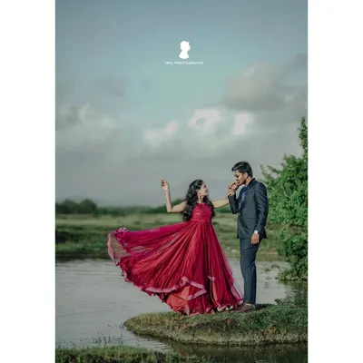 A classic, romantic pre-wedding pose by the water. The way she leans back in her flowing red dress creates a beautiful, dance like motion that looks stunning on camera.