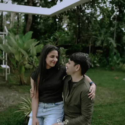 A casual, sweet moment between a couple, sharing a look of love in a beautiful garden setting.