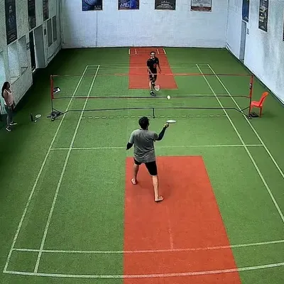 A high-angle view of a singles match. You can see the player getting ready to serve and start the point.