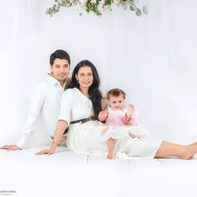 A beautiful family portrait session featuring parents and their baby girl, styled in coordinating white outfits for a clean and classic look.