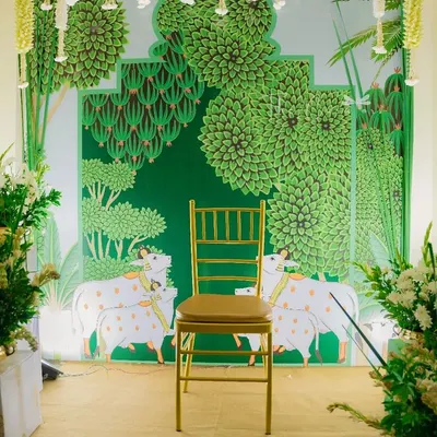 The centerpiece of our Haldi decor: a stunning backdrop inspired by traditional Pichwai art, featuring sacred cows and lush greenery, ready for the ceremony.
