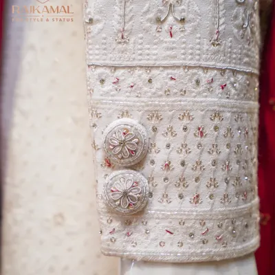 A close-up of the sleeve of my classic white sherwani, showing the handcrafted buttons and the delicate, tone-on-tone embroidery.