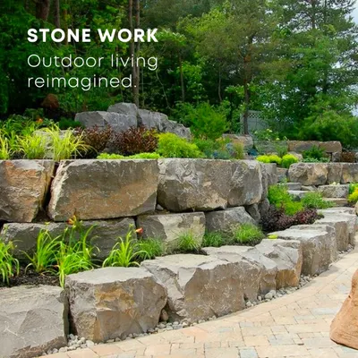 Natural stonework provides a strong foundation for any garden design. Here, large boulders create a multi-level retaining wall, adding a rugged, organic texture that beautifully complements the surrounding plants. We use hardscaping to bring structure and permanence to the landscape.
