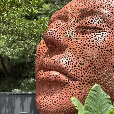 'The Stillness' is a portrait of quiet power, crafted from perforated mild steel. Placed outdoors, this monumental head becomes a part of the landscape, its serene expression offering a point of reflection amidst the chaos of daily life.
