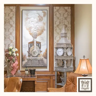 This impressive 3D wall art of a steam engine is a true statement piece. Its textured details and grand scale bring a sense of history and adventure to this room, which also features a Big Ben-style clock.
