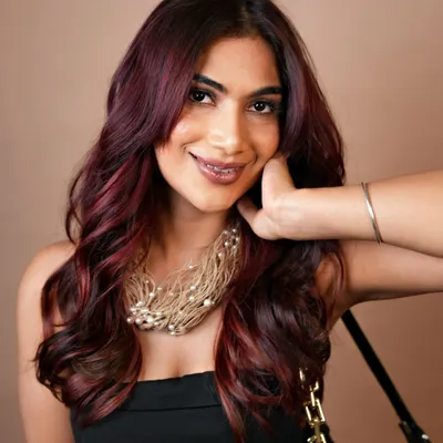Elegance with a splash of crimson. This vibrant red balayage is a perfect example of our custom color work, creating a bold yet sophisticated statement.