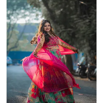 Twirling into her Mehendi function with joy! This bride's look is all about color and celebration, with a fresh, dewy makeup look that complements her vibrant floral lehenga.