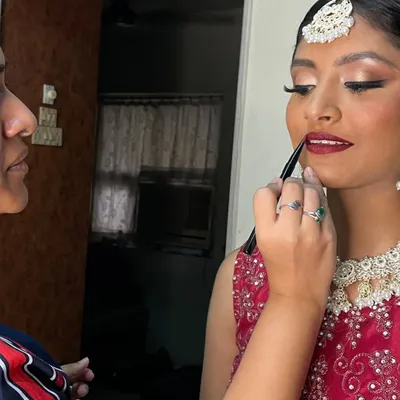 The final touch. Applying the perfect shade of red lipstick to complete this bride's glamorous look. It's these small details that bring everything together.