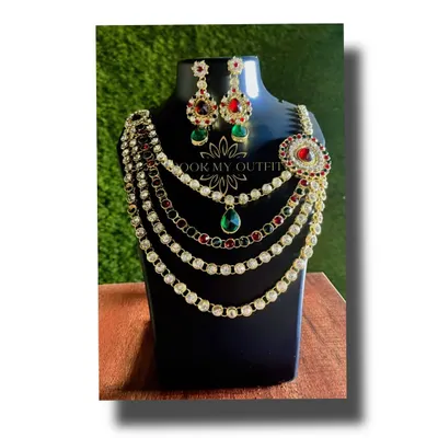 Make a statement at your next event with this multi-layered necklace. It combines rows of white stones with pops of red and green, making it a versatile piece that works for both weddings and parties.