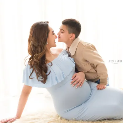A tender moment between a mother-to-be and her son. This light and airy maternity portrait captures the sweet connection as they await the new baby.