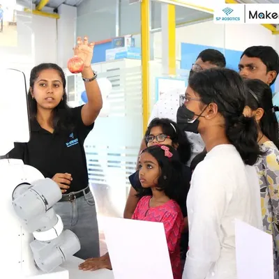 An instructor from our team demonstrates the capabilities of a robotic arm to an engaged audience at our Maker Lab. Our workshops are interactive, encouraging questions and direct participation.