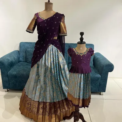 The ultimate mom-and-daughter goal. ✨ This matching set features a stunning Langa Voni for mom and a coordinating Pattu Pavadai for her daughter, using a beautiful combination of purple and powder blue brocade.