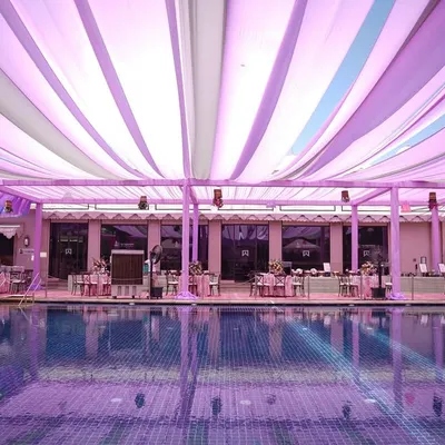 A dreamy poolside Mehendi setup. We used flowing drapes in shades of lilac, lavender, and white to create a soft, ethereal canopy over the entire area, reflecting beautifully in the water.