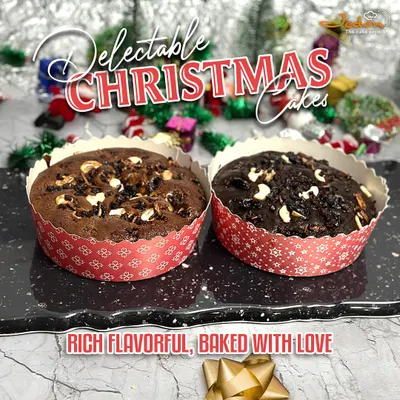 Our delectable Christmas cakes are rich, flavorful, and baked with love. This image presents two individual plum cakes in festive red paper moulds, loaded with nuts and dried fruits for a truly indulgent holiday treat.