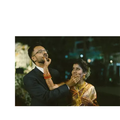 A playful moment during the reception where the bride lovingly smudges cake on the groom's face. It’s these candid, fun-filled interactions that perfectly capture a couple's chemistry and the relaxed joy of the celebration.