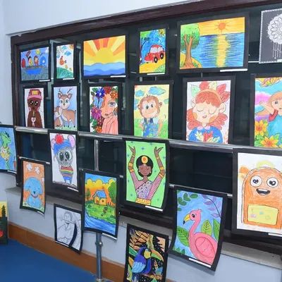A vibrant display of children's artwork at our Fine Arts Exhibition. This wall showcases a range of subjects, from landscapes to cartoon characters, highlighting the creative freedom we encourage in our kids' art classes.