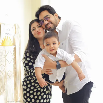 A bright and happy family portrait taken in our indoor studio. The classic black and white outfits and the simple, light-filled setting create a timeless look.