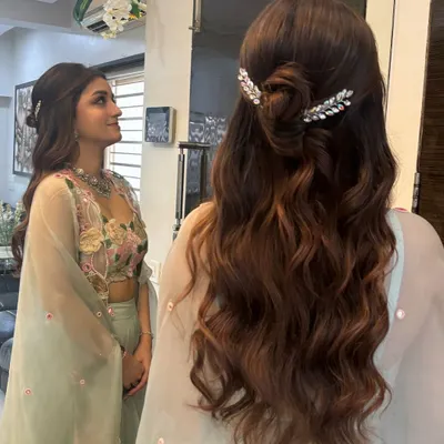 A beautiful half-up style featuring a knotted bun and soft waves. I added two sparkling, leaf-shaped clips to frame the bun, creating a look that is both elegant and modern. This is perfect for an engagement or reception.