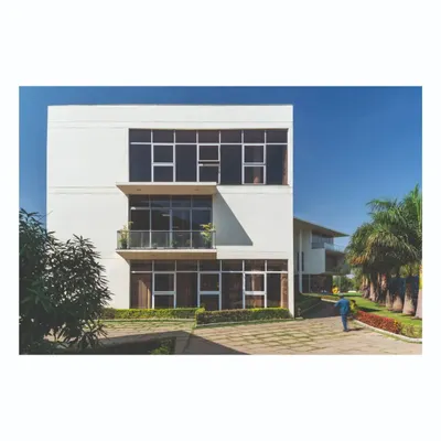 An exterior view of the office block at the Ajax factory campus, showcasing the clean, modernist lines and the integration of the building with the surrounding manicured landscape.