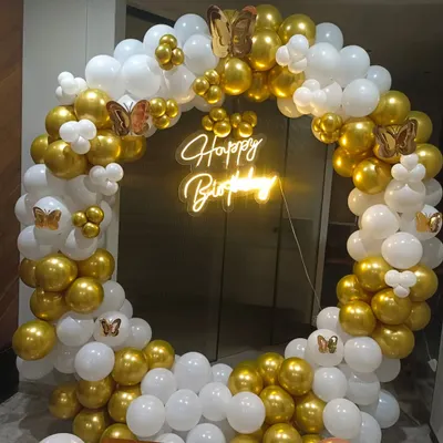 18th birthday ke liye yeh ek elegant gold aur white balloon ring decoration hai. Iske saath humne butterfly cutouts aur ek 'Happy Birthday' neon sign lagaya hai, jo isko ek classy look de raha hai.