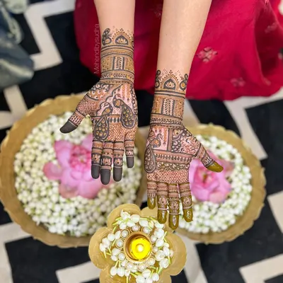 An elegant and traditional design for the mother of the bride. This pattern features beautiful peacock motifs and is set against a festive backdrop of flowers and diyas.