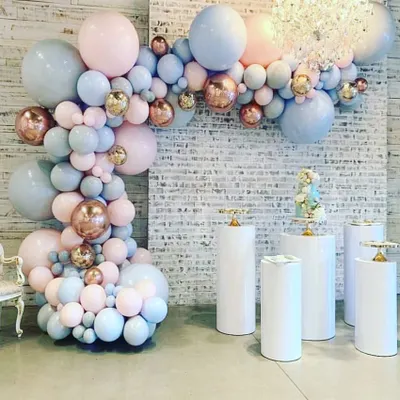 This organic balloon garland demonstrates a softer color palette, mixing pastel pink and blue with metallic rose gold accents. Paired with clean white pedestals, this versatile design can be customized for anniversaries, engagements, or any elegant celebration.