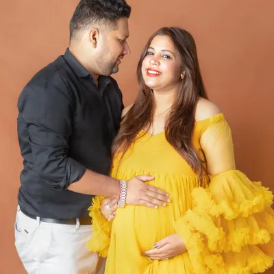 Sharing a sweet glance during their couple maternity photoshoot. I always aim to capture these unscripted, real moments of connection that tell your unique love story against a simple, warm backdrop.
