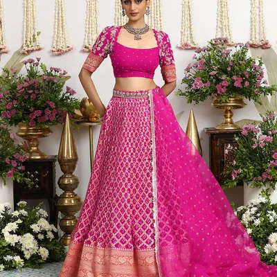 A vision in fuchsia, this Bandhani lehenga from our Kesariya collection is a celebration of vibrant color and heritage craft. The full ensemble, complete with a Banarasi border and embellished blouse, is perfect for the modern bride.