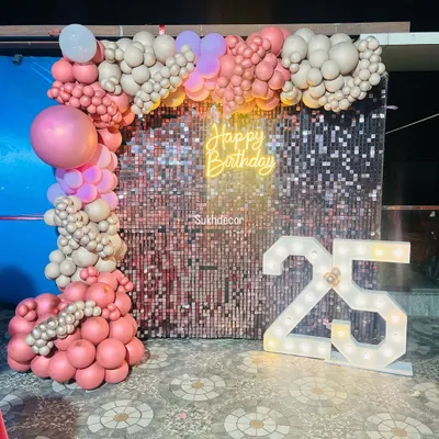 This 25th birthday setup is the definition of glam. The rose gold shimmer wall provides a sparkling backdrop for the organic balloon arch, neon sign, and large '25' marquee numbers.