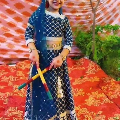 Our little performer dressed as Radha, holding dandiya sticks for a festive Janmashtami dance number. We pay close attention to costume details to make every child's performance special.