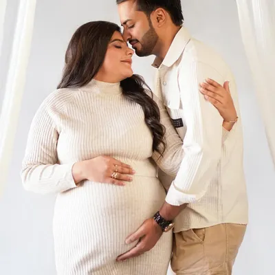 A tender moment between partners, captured in soft, neutral tones for a timeless feel. This is what celebrating your journey together looks like.